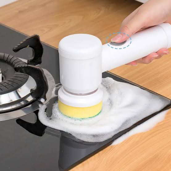Electric brush scrubbing a stovetop